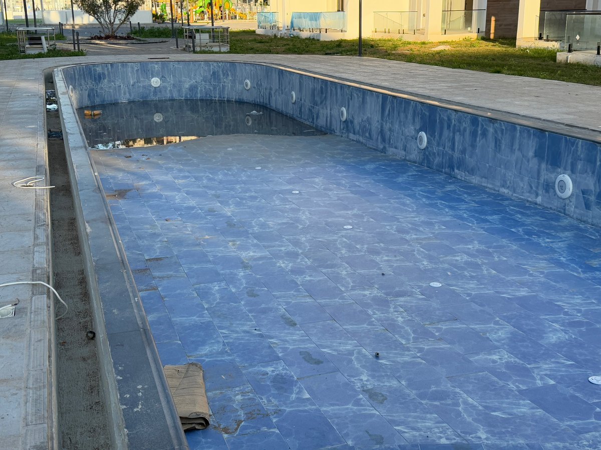 Piscina con azulejos azules y reflejo del entorno